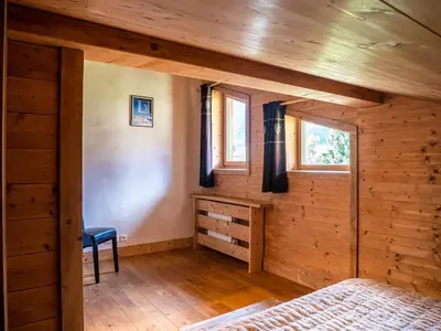 a room with wooden walls and a bed and windows at Demi Chalet au coeur de Chamonix - Zefi in Chamonix-Mont-Blanc