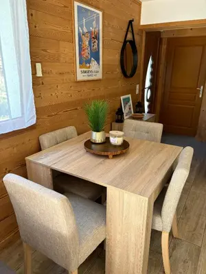 a dining room with a wooden table and chairs at Agora in Samoëns