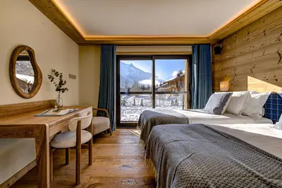 a hotel room with two beds and a window at Chalet Josephine, Chamonix Les Bois in Chamonix-Mont-Blanc