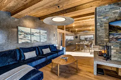a living room with a blue couch and a fireplace at Chalet Josephine, Chamonix Les Bois in Chamonix-Mont-Blanc