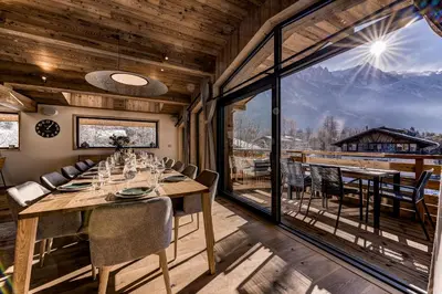 a dining room with a table and a large window at Chalet Josephine, Chamonix Les Bois in Chamonix-Mont-Blanc