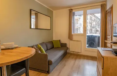 a living room with a couch and a table at Apartment Lognan 1 - A Chamonix Mont Blanc Haven in Chamonix-Mont-Blanc