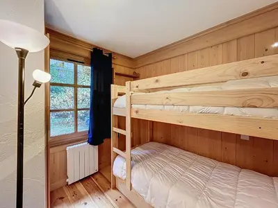 a bedroom with two bunk beds and a lamp at Confortable 2 pièces avec jardin, parking, face au Mont Blanc - FR-1-560-152 in Combloux