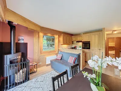 a living room with a couch and a kitchen at Confortable 2 pièces avec jardin, parking, face au Mont Blanc - FR-1-560-152 in Combloux