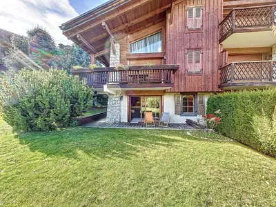 a large house with a balcony and a yard at Confortable 2 pièces avec jardin, parking, face au Mont Blanc - FR-1-560-152 in Combloux