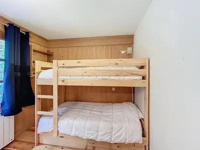 a wooden bunk bed in a room with a wall at Confortable 2 pièces avec jardin, parking, face au Mont Blanc - FR-1-560-152 in Combloux
