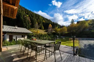 a patio with a table and chairs on a deck at Chalet Cotes du Lavancher in Chamonix-Mont-Blanc
