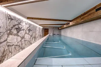 an indoor swimming pool with a stone wall at Chalet Cotes du Lavancher in Chamonix-Mont-Blanc