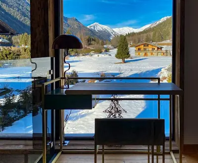 a desk in front of a window with a view of snow at Chalet Cotes du Lavancher in Chamonix-Mont-Blanc