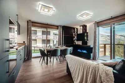 a kitchen and living room with a table and chairs at Apartment Nid des Neiges - Perfect for families in Combloux
