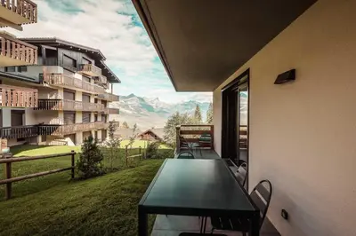 a table in a balcony with a view of a mountain at Apartment Nid des Neiges - Perfect for families in Combloux