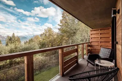 a balcony with two chairs and a table and a view at Apartment Nid des Neiges - Perfect for families in Combloux