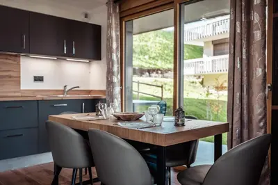 a kitchen with a wooden table and chairs at Apartment Nid des Neiges - Perfect for families in Combloux