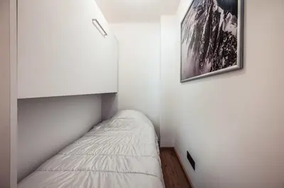 a small room with a bed and a picture on the wall at Apartment Nid des Neiges - Perfect for families in Combloux