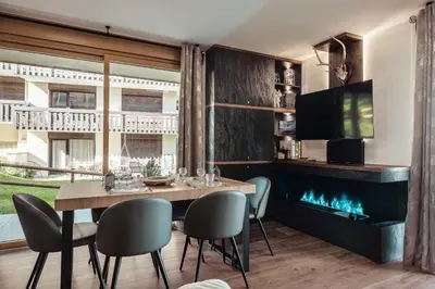 a dining room with a table and a fireplace at Apartment Nid des Neiges - Perfect for families in Combloux