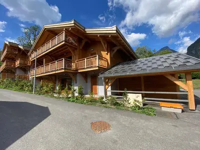a large wooden house with a gambrel roof at Bel appartement T3 en résidence neuve avec parking et WIFI, proche du village et ski-bus - FR-1-624-168 in Samoëns