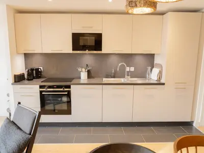 a kitchen with white cabinets and a sink at Bel appartement T3 en résidence neuve avec parking et WIFI, proche du village et ski-bus - FR-1-624-168 in Samoëns