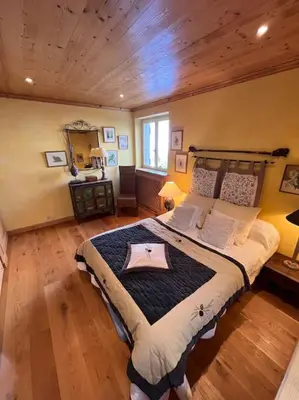 a bedroom with a large bed with a wooden ceiling at Très bel appartement à Megève in Megève