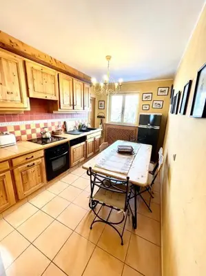 a kitchen with a table and a refrigerator at Très bel appartement à Megève in Megève