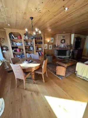 a living room with a wooden table and chairs at Très bel appartement à Megève in Megève