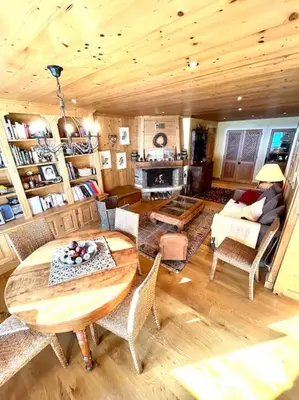 a living room with a wooden ceiling and a table and chairs at Très bel appartement à Megève in Megève