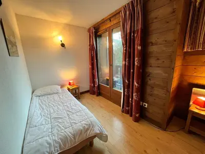 a bedroom with a bed and a large window at Chalet avec terrasse et animaux acceptés, proche centre et ski-bus - FR-1-624-169 in Samoëns