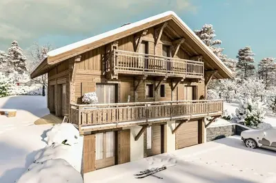 a log cabin with a deck in the snow at Le chalet des belges - Saint-Gervais in Saint-Gervais-les-Bains