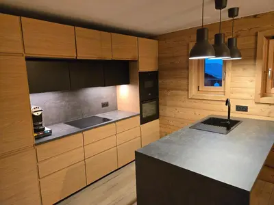 a kitchen with wooden cabinets and a counter top at Le chalet des belges - Saint-Gervais in Saint-Gervais-les-Bains