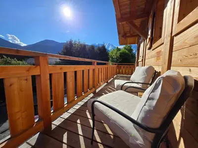 a deck with chairs and a view of the mountains at Le chalet des belges - Saint-Gervais in Saint-Gervais-les-Bains