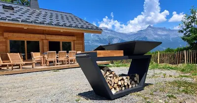 a fire pit in front of a log cabin at Le chalet des belges - Saint-Gervais in Saint-Gervais-les-Bains
