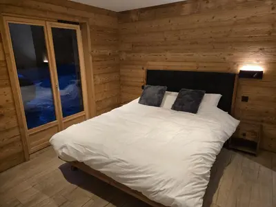 a bedroom with a bed with white sheets and pillows at Le chalet des belges - Saint-Gervais in Saint-Gervais-les-Bains