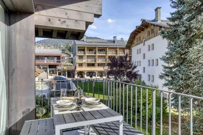 a table on a balcony with a view of a building at Appartement Orso in Megève