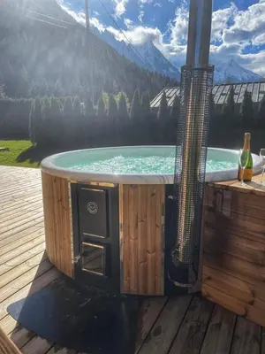 a hot tub on a deck with a view of a mountain at Premium 200sqm Chalet in Chamonix Valley ! in Chamonix-Mont-Blanc