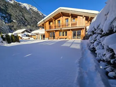 a snow covered road in front of a log cabin at Premium 200sqm Chalet in Chamonix Valley ! in Chamonix-Mont-Blanc