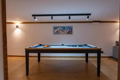 a pool table in the middle of a room at Premium 200sqm Chalet in Chamonix Valley ! in Chamonix-Mont-Blanc