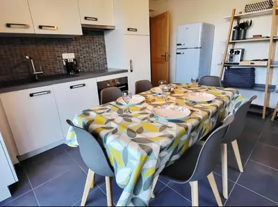 a dining room table with chairs and a table cloth at Zorta - Ground floor apartment with private garden in Samoëns