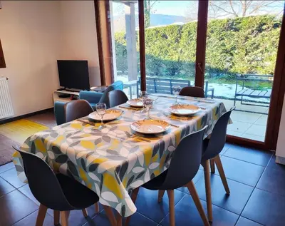 a dining room table with chairs and a table cloth at Zorta - Ground floor apartment with private garden in Samoëns