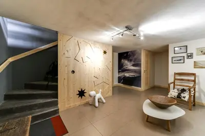 a living room with a staircase and a teddy bear at Chalet lux et Design Chamonix in Servoz