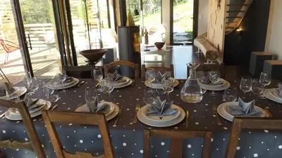 a table with plates and glasses on top of it at Chalet lux et Design Chamonix in Servoz