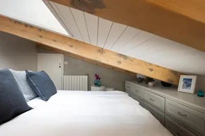 a bedroom with a large white bed in a attic at 1 bedroom apartment plus mezzanine in Chamonix-Mont-Blanc