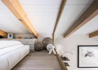 a bedroom with a white bed and wooden ceilings at 1 bedroom apartment plus mezzanine in Chamonix-Mont-Blanc
