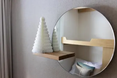a mirror with a white vase on a shelf at 1 bedroom apartment plus mezzanine in Chamonix-Mont-Blanc