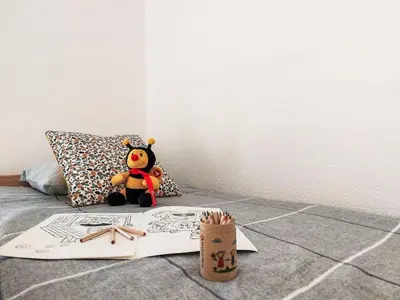a teddy bear sitting on a bed with a book at Studio La Comtesse-11 by Interhome in Saint-Gervais-les-Bains