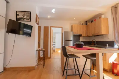 a kitchen with a counter and a kitchen island with chairs at Appartement lumineux à Chamonix avec vue imprenable sur Mont Blanc et parking in Chamonix-Mont-Blanc