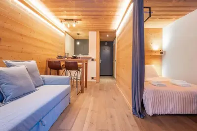 a room with a bed and a kitchen with a table at Chamois Blanc - Quiet Studio close to the town centre - By Cozee Rentals in Chamonix-Mont-Blanc