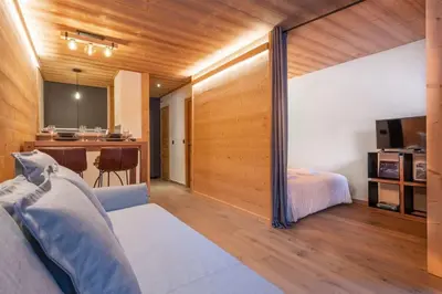 a room with a bed and a kitchen with a table at Chamois Blanc - Quiet Studio close to the town centre - By Cozee Rentals in Chamonix-Mont-Blanc