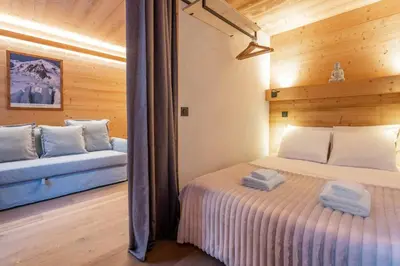 a bedroom with a bed and a couch in a room at Chamois Blanc - Quiet Studio close to the town centre - By Cozee Rentals in Chamonix-Mont-Blanc