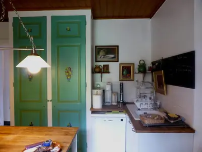 a kitchen with a green door and a counter at Chalet station jusqu'à 13 personnes 5 nuits minimum ou 7 en période de vacances scolaires in Samoëns