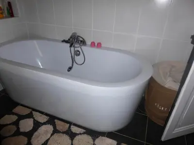 a white bath tub with a faucet in a bathroom at Chalet station jusqu'à 13 personnes 5 nuits minimum ou 7 en période de vacances scolaires in Samoëns