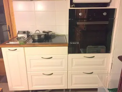 a kitchen with white cabinets and a stove top oven at Chalet station jusqu'à 13 personnes 5 nuits minimum ou 7 en période de vacances scolaires in Samoëns